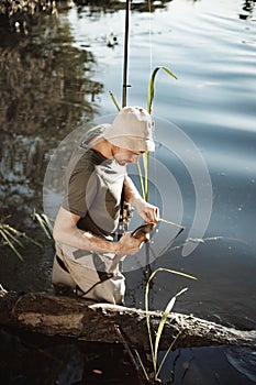 Young fisherman with fishing rod near the lake at summer