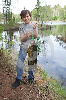 Young fisherman proudly holds up stringer of walleyes