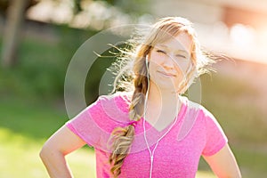 Young Fit Adult Woman Outdoors Workout Clothes Listening To Music with Earphones.