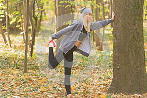 Young and fit adult woman stretching her muscles in the forest. Healthy lifestyle