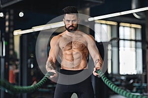 Young fit athlete working out in functional training gym