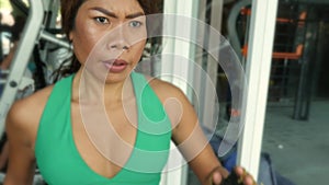 Young fit and athletic Asian Thai woman with fit body running on gym treadmill sweating training hard jogging workout