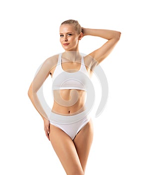 Young, fit and beautiful woman in white swimsuit over white background. The concept of healthcare, diet, sport and