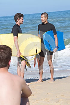 young fit bodyboarders on beach