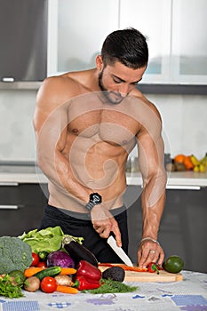 Young fit bodybuilder in the kitchen