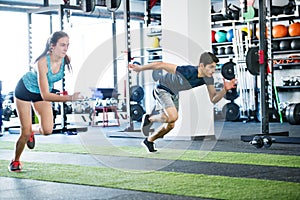 Young fit couple in gym fast running.