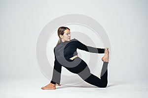 Young fit female athlete doing stretching. Studio shot