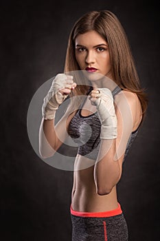 Young and fit female fighter in fighting stand