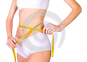 Young fit female measuring waist