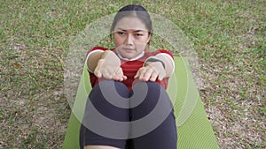 Young fit happy Asian woman doing sit up exercise
