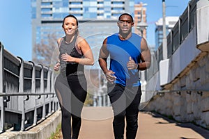 A young fit healthy lifestyle living modern couple exercising in urban city, street workout, free running, downtown