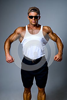 A young and fit male model posing his muscles