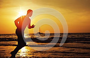 Young, fit man doing jogging on a tropical beach