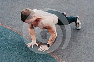 Young fit man doing push ups in a gym