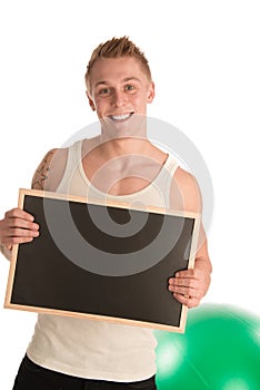 Young fit man holding blackboard