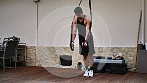 Young fit man using elastic exercise rope outdoor