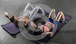 Young fit man and woman exercising in a gym