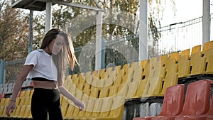 Young fit slim asian female in sportswear stretching legs at tribune of stadium