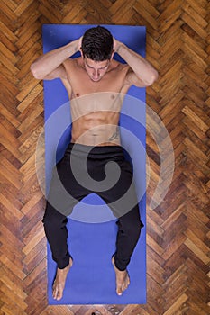 Young fit slim muscular abs man exercise elevated view