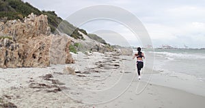 Young fit sports woman jogging on the beach. Super slow motion stabilizer shots.