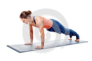 Young fit sporty woman does Hatha yoga plank asana