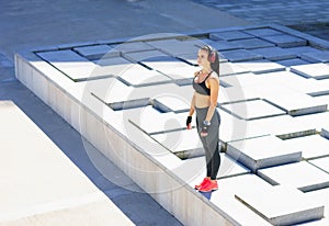 Young, fit and sporty woman preparing for urban jogging.