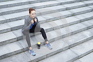 Young, fit and sporty woman resting after the training. Fitness, sport, urban jogging and healthy lifestyle concept.