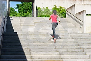 Young, fit and sporty woman running up the stairs. Fitness, sport, urban jogging and healthy lifestyle concept.