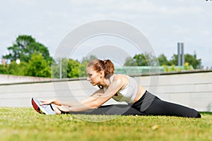 Young, fit and sporty woman stretching in the park. Fitness, sport, urban and healthy lifestyle concept.