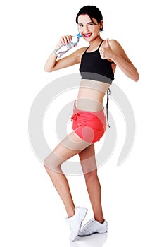 Young fit woman drinking mineral water