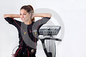 Young fit woman exercise on electro muscular stimulation machine