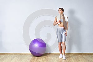 Young fit woman exercising in a gym. Sports girl is training cross fitness with Pilates Balls