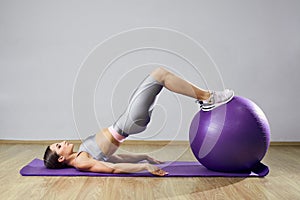 Young fit woman exercising in a gym. Sports girl is training cross fitness with Pilates Balls