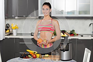 Young fit woman with fruits, in the kitchen