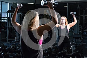 Young fit woman at the gym doing heavylifting exercise with bar
