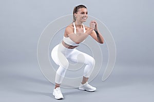 Young fit woman. Healthy lifestyle and sports concept. Isolated on gray.