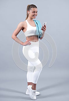 Young fit woman. Healthy lifestyle and sports concept. Isolated on gray.
