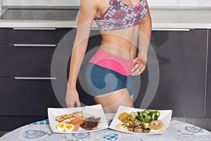 Young fit woman in the kitchen; animal versus plant proteins