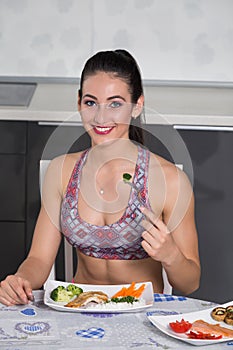 Young fit woman in the kitchen, eating