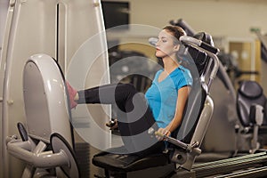Young fit woman leg press in a fitness center. Portrait of fitness girl in the gym, lifestyle concept..