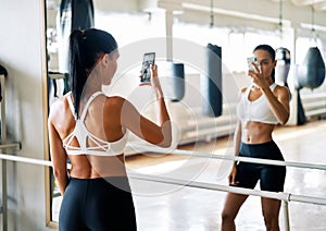 Young fit woman making a selfie in gym after exercise