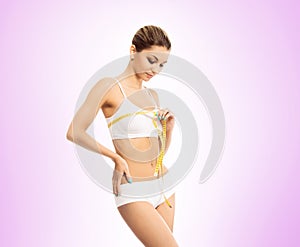 Young and fit woman measuring her chest with a tape