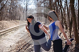 Young fit woman motivate her overweight friend at outdoor workou