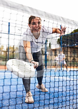 Young fit woman playing paddle tennis outdoors