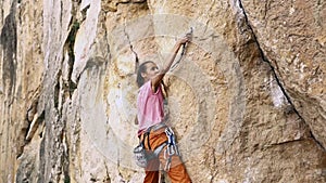 Young fit woman rock climbing on sport route outdoors