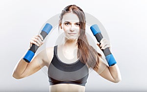 Young fit woman training with dumbbells