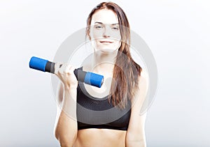 Young fit woman training with dumbbells