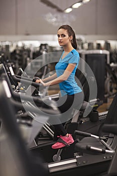 Young fit woman using a bicycle in a fitness center, cardio. Portrait of fitness girl in the gym, lifestyle concept..
