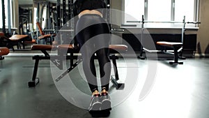 Young fitness brunette girl doing pushups on a training bench in the gym. concept of sport and healthy lifestyle