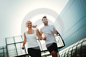 Young fitness couple running in urban area